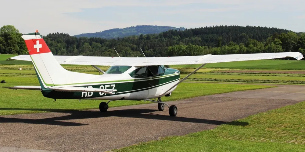 Single engine Cessna parked on a grass airfield