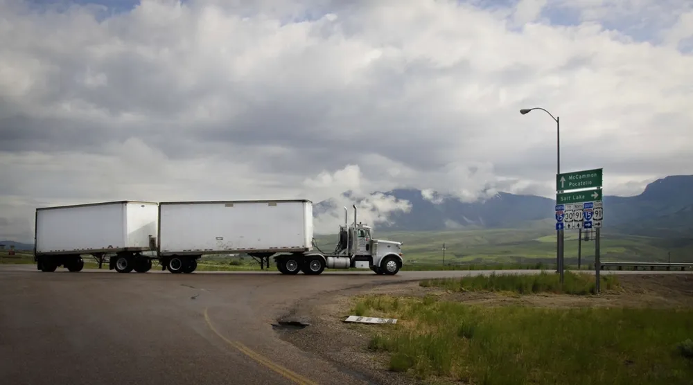 Semi truck pulling double trailers on an open road
